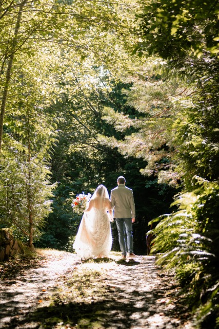 Couple walking into a lush green forest together
